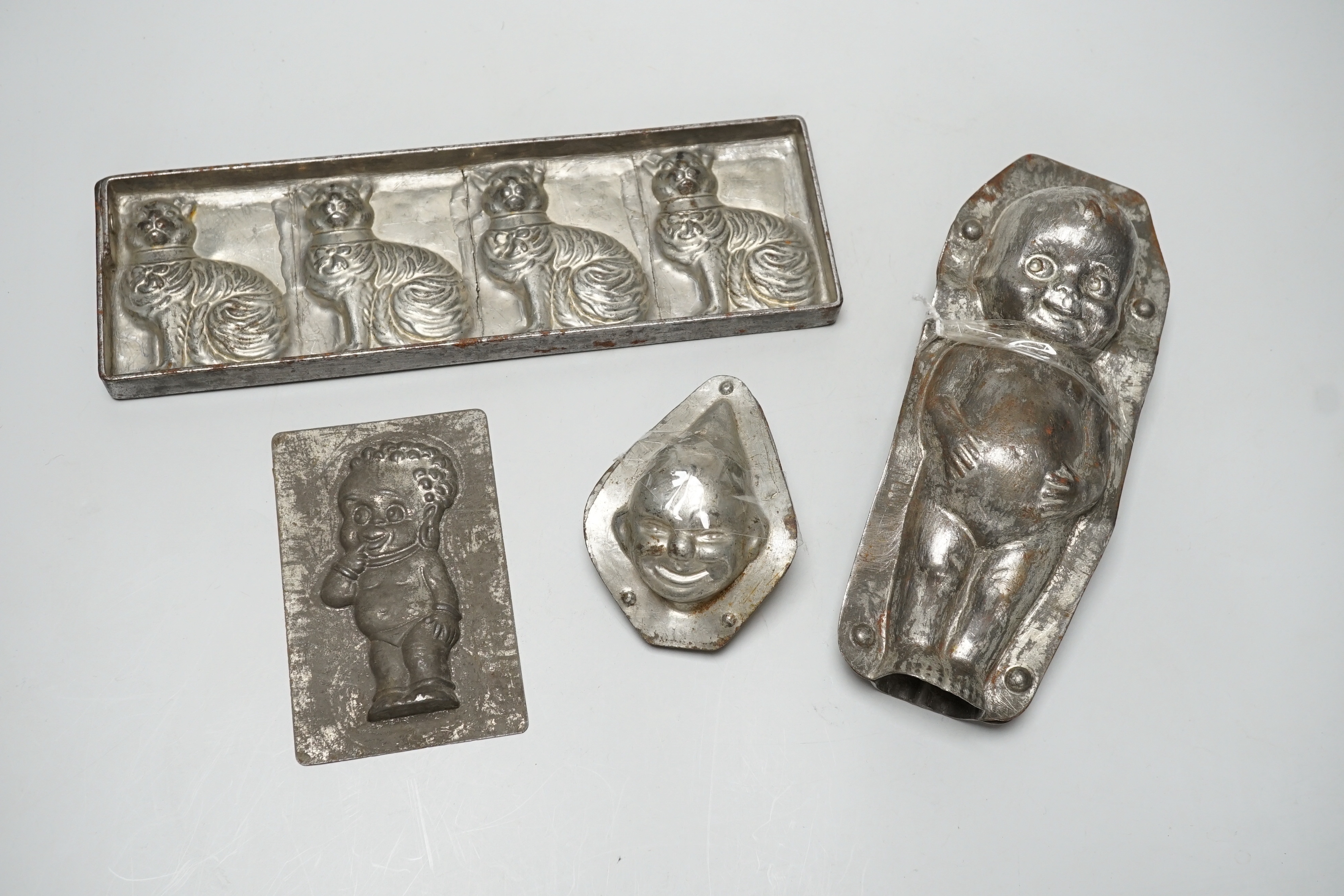 Four chocolate mould tins: a cat, a kewpie and two others